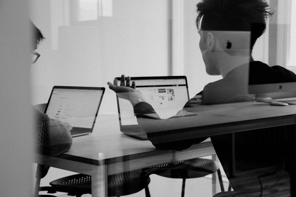 A black and white photo of a compliance CFD broker team in a meeting.