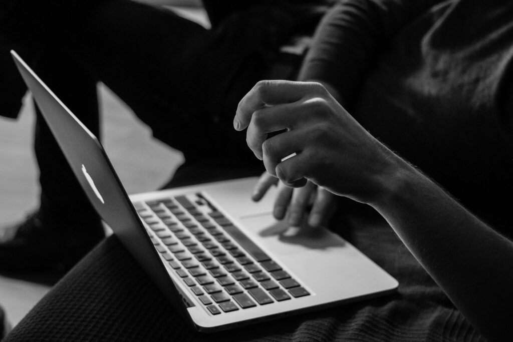 A monochrome photo of someone working on their laptop, online banking