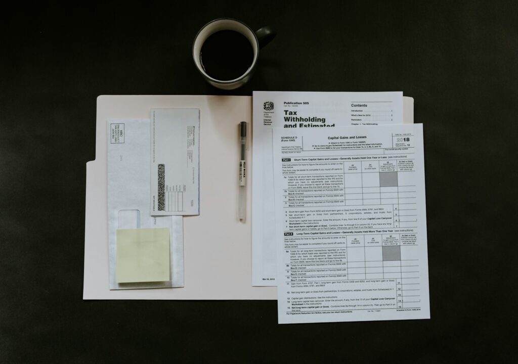 A black background with an array of financial tax documents laid out in a folder