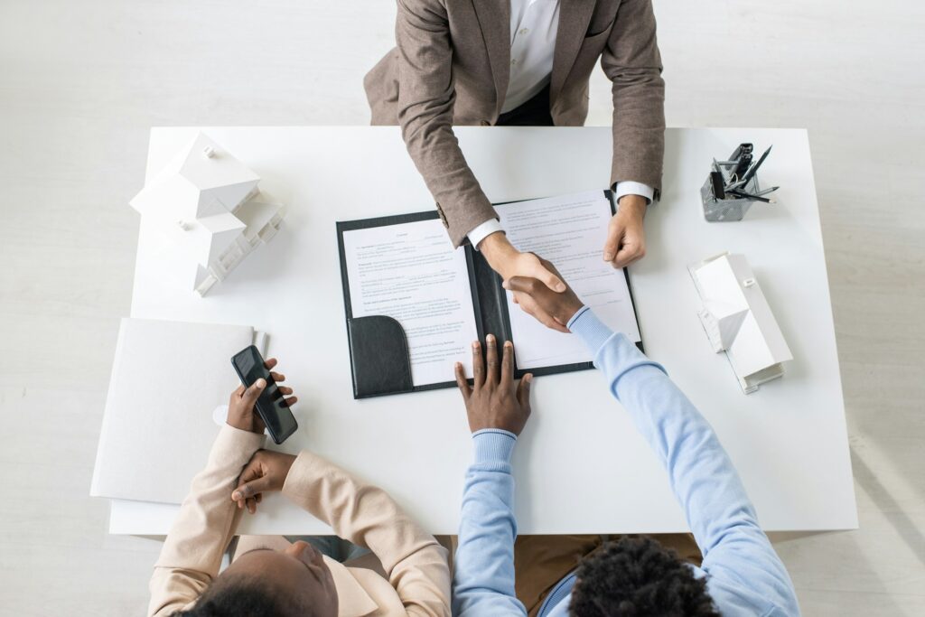 7 documents your bank actually needs from a crypto exchange 4 A top down view of a client shaking hands with a business after a successful application process