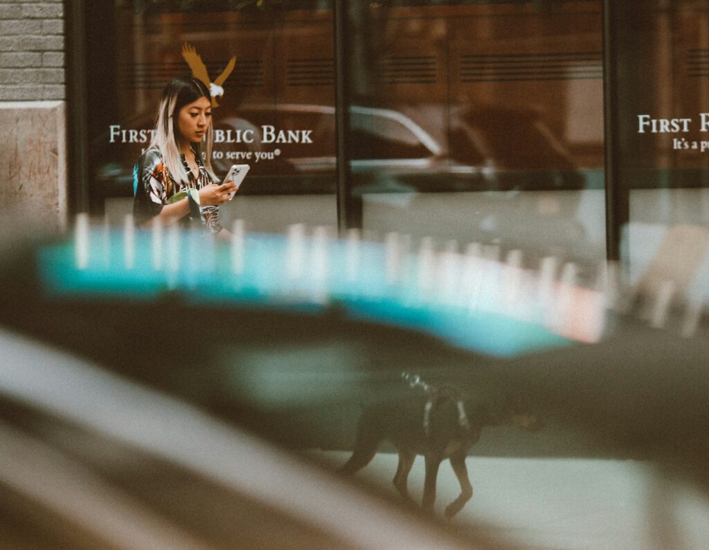What is de-risking — and why is it happening to your business? 3 A woman walks past the front of a national us bank while on her smartphone