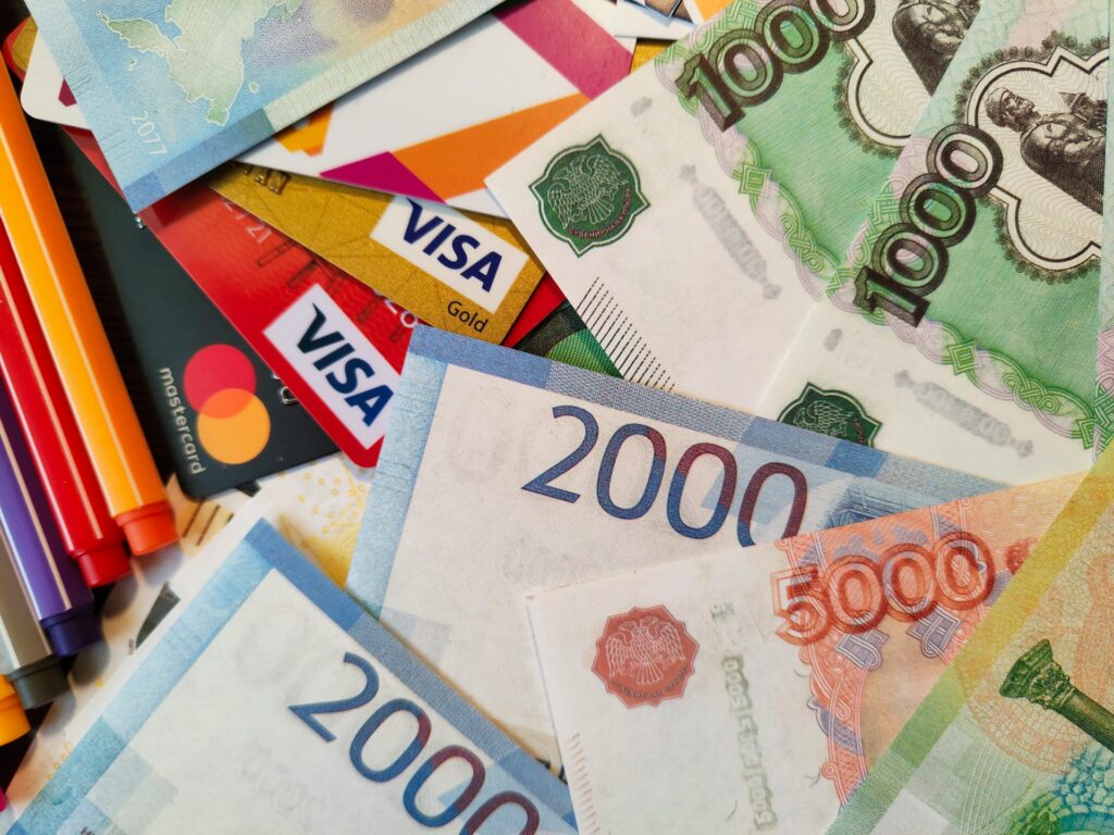 An assortment of different monetary bank notes and banking cards from various countries, all requiring IBANs to send money to